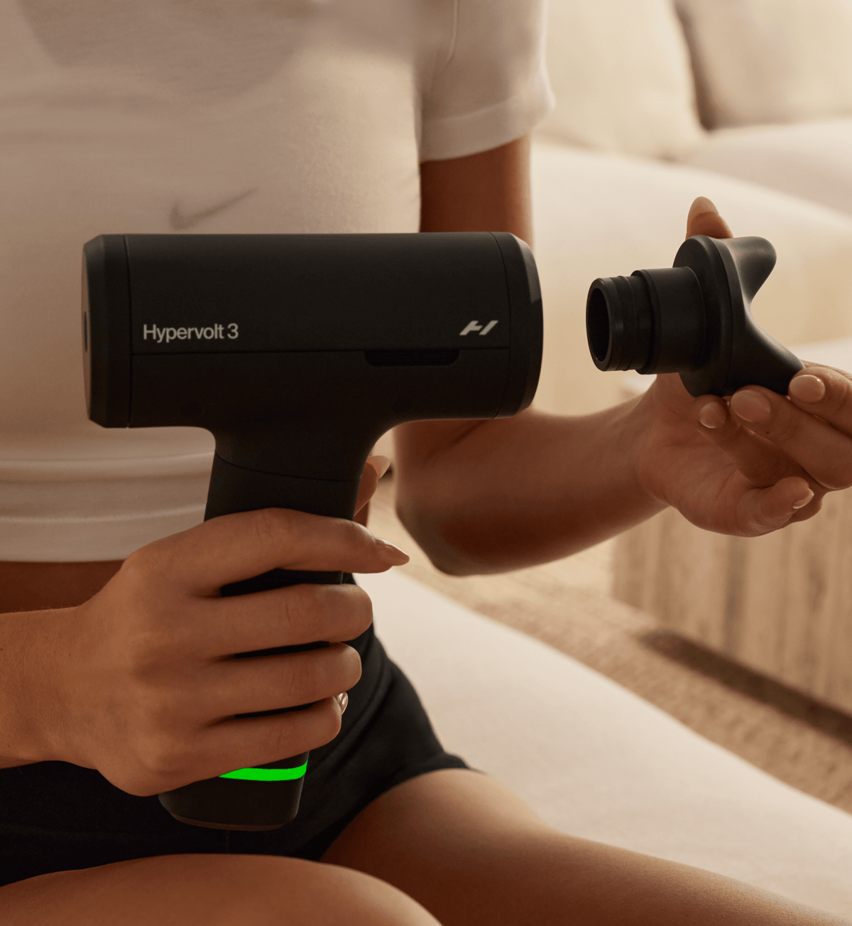 Person changing a head attachment on the Hypervolt 3
