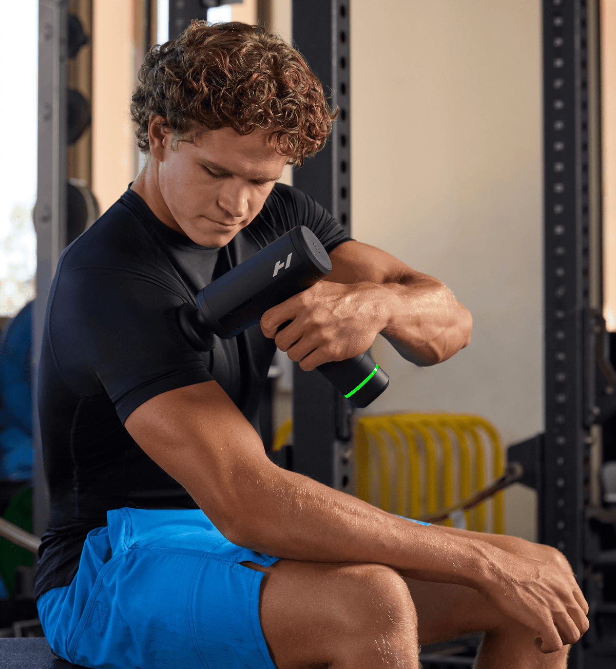 Homme en salle de sport utilisant le Hypervolt 3 Pro sur la jambe