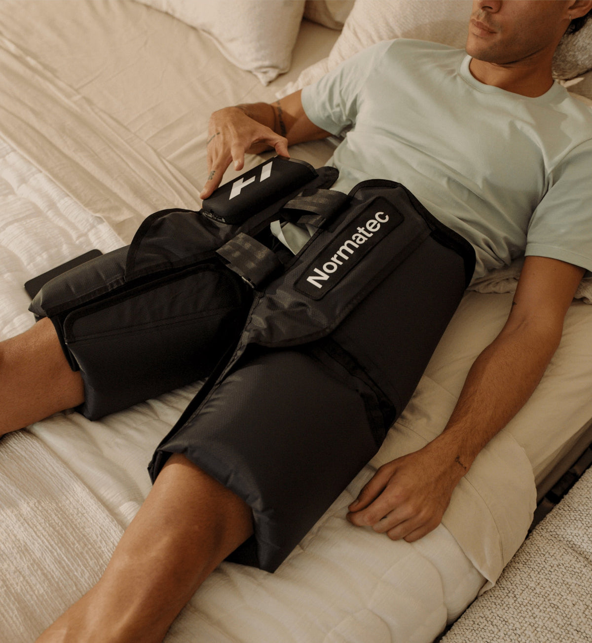 Personne utilisant les Normatec Premier Hips dans une chambre