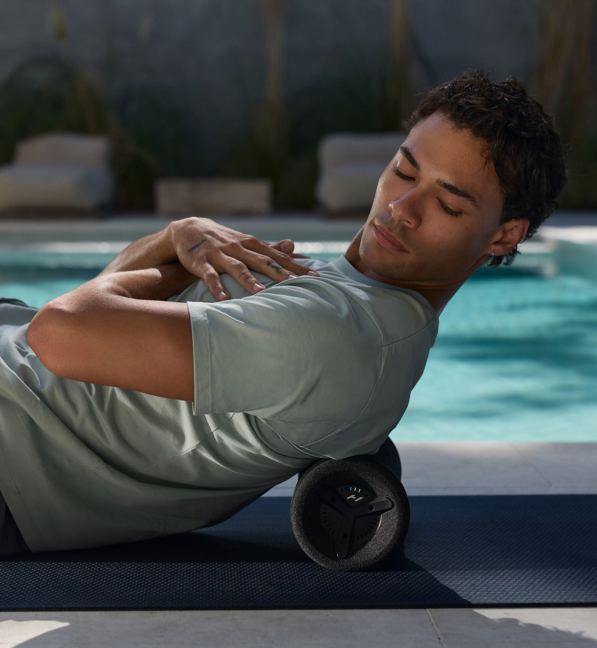 Man using a vyper 3 foam roller by a pool